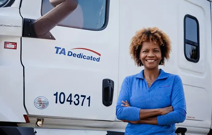 A dedicated driver standing next to her truck.