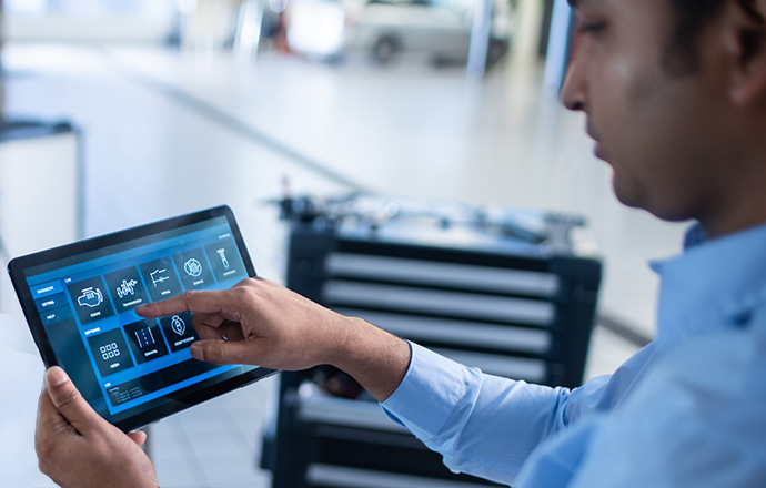 Car Service Manager or Mechanic Uses a Tablet Computer with a Futuristic Interactive Diagnostics Software. Specialist Inspecting the Vehicle in Order to Find Broken Components In the Engine Bay.