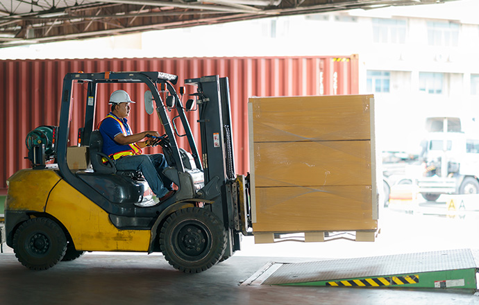 A man operating a forklift at a shipping yard.